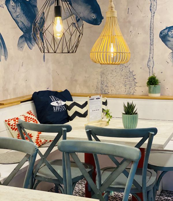 Gemütliche Sitzecke mit maritimer Deko und Fischtapete im Restaurant Strandgut auf dem Stover Strand Campingplatz Hamburg nah.